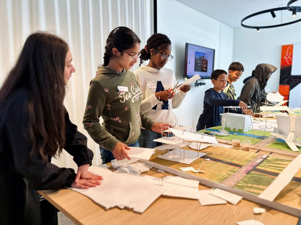TAJO-jongeren knutselen rond een tafel met papier.